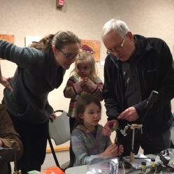 A young fly tyer gets some instruction during a free community workshop on fly tying during the Feathers and Fingertips exhibition
